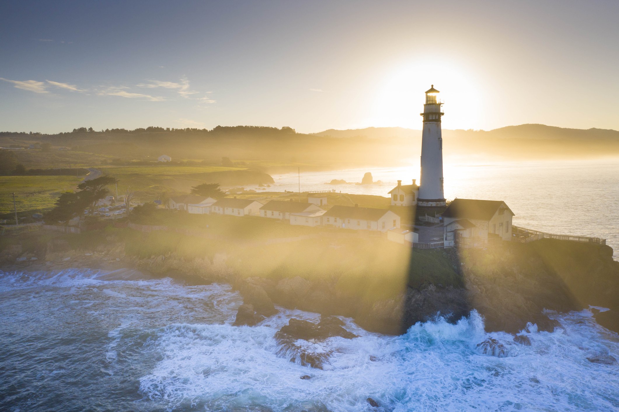 A lighthouse standing over the Oregon coast at dusk